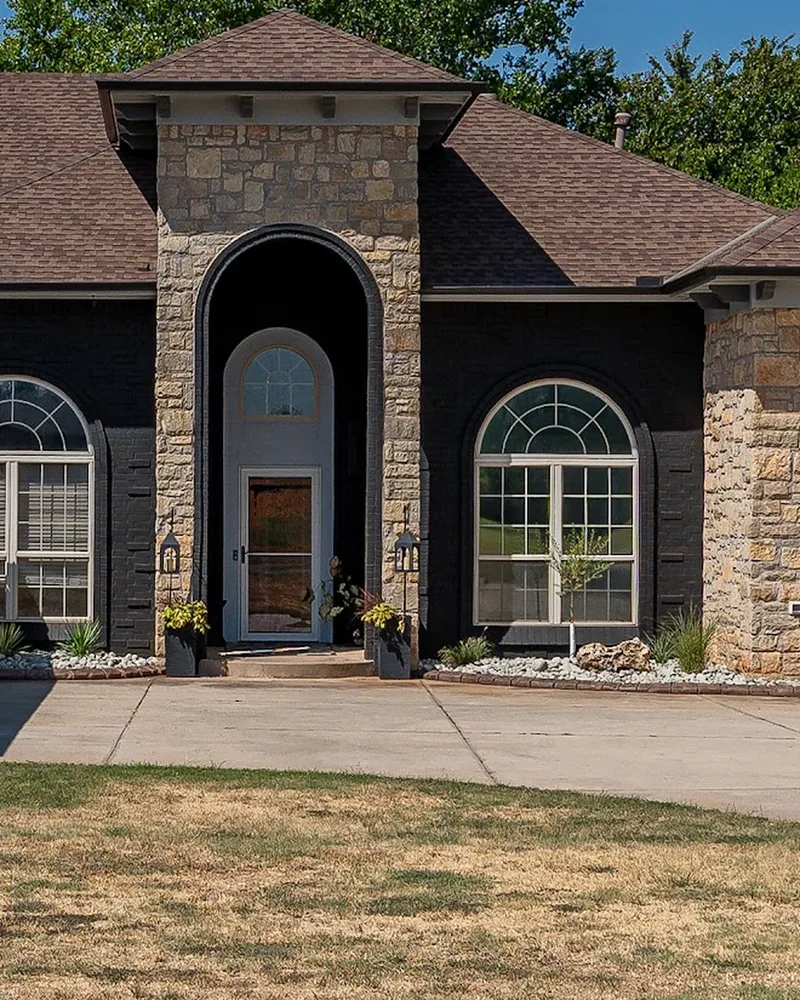 After: the same entry arch with the brick painted Celtic Stone charcoal black and the stone left natural