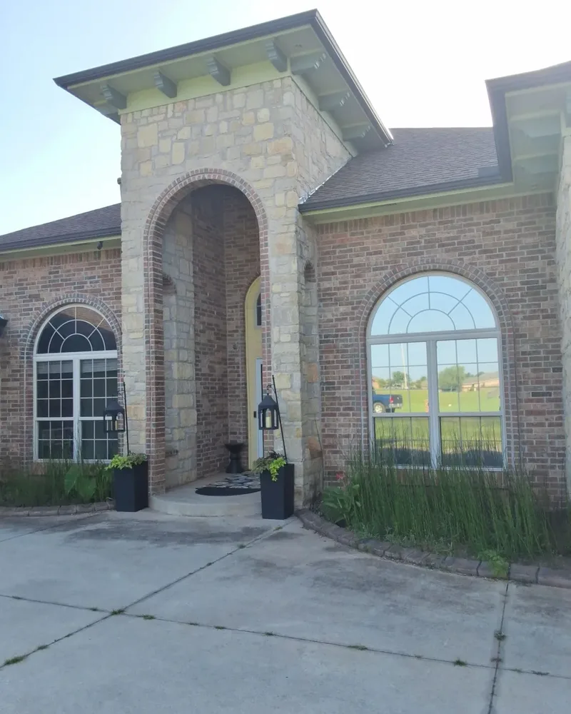 Before: Edmond home's stone entry arch surrounded by red-orange brick and pale green trim